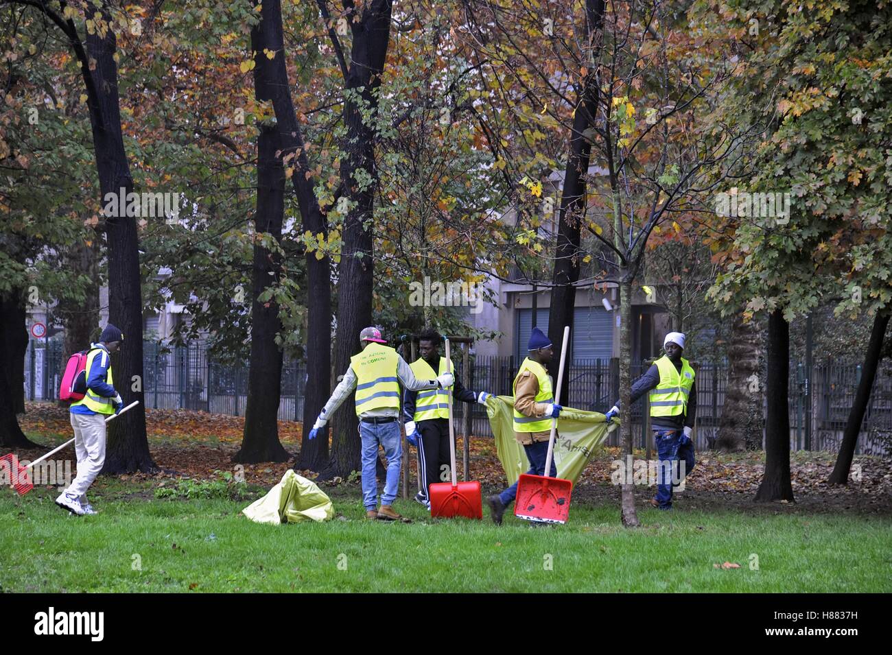 Mailand (Italien), eine Gruppe von Flüchtlingen und Asylsuchenden aufräumen toten Blätter von den Parks der Stadt als ehrenamtliche Arbeit Stockfoto