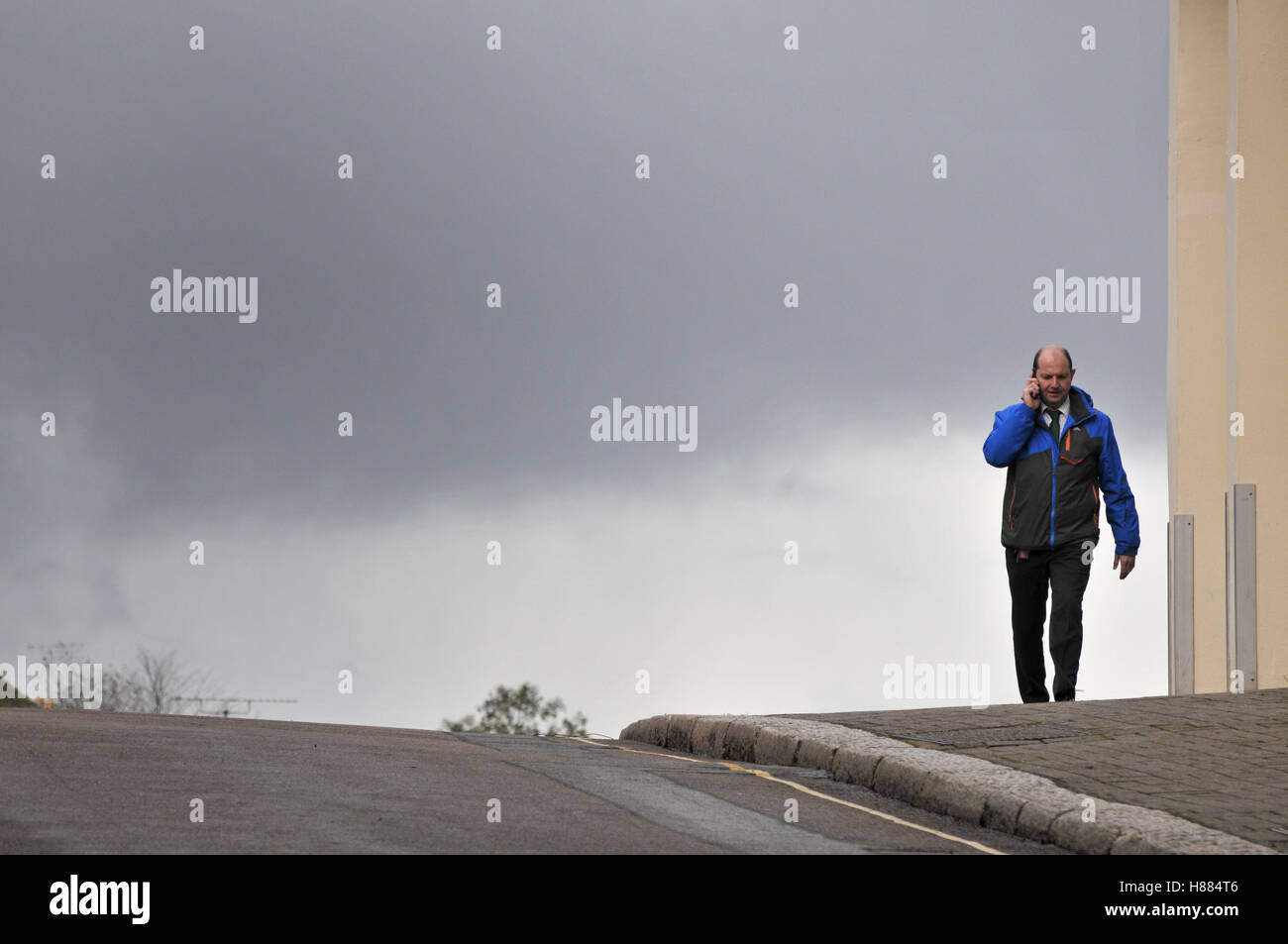 Mann auf seinem Handy an einem verregneten Tag in Falmouth, Cornwall Stockfoto