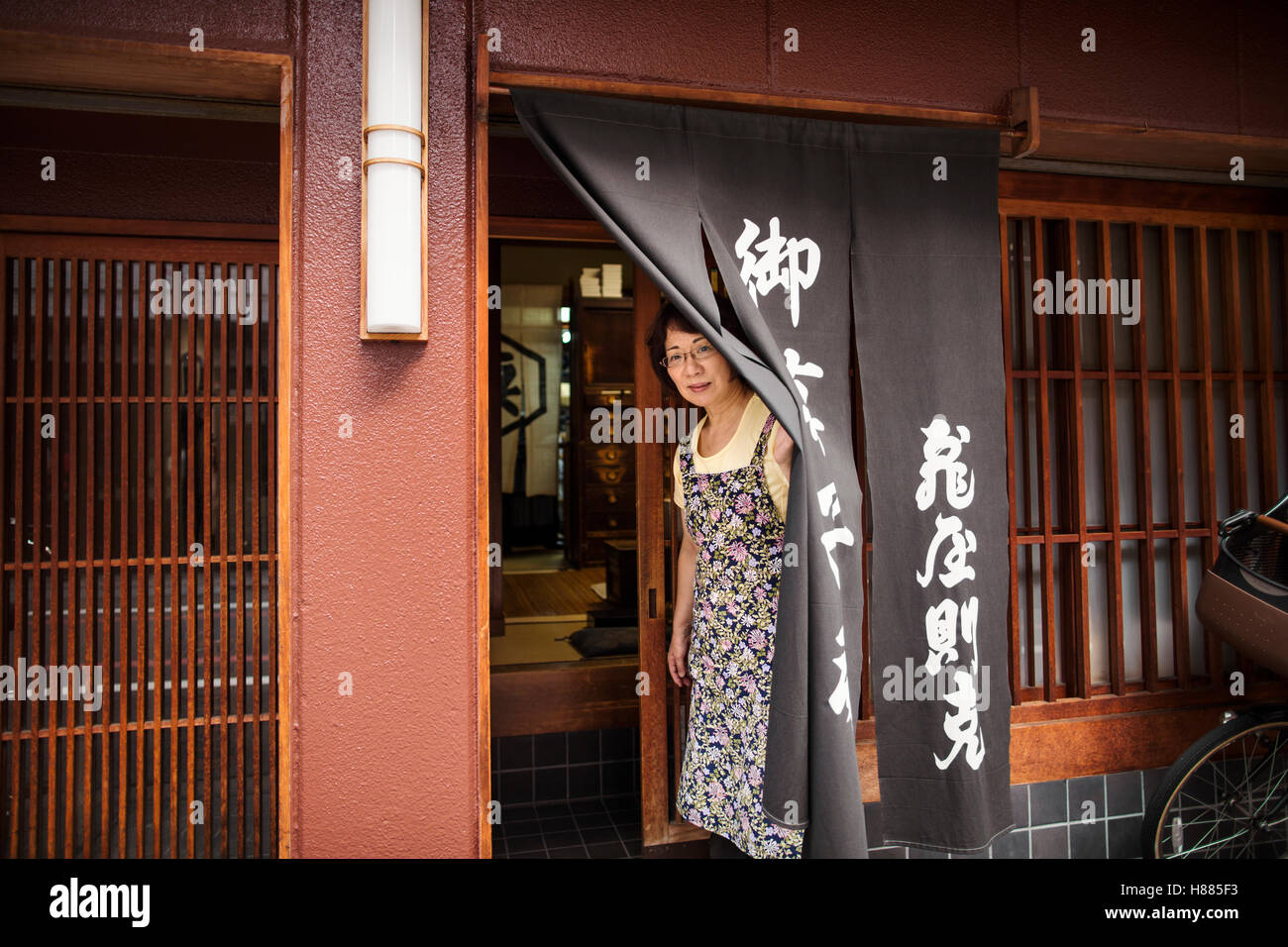 Eine kleinen Handwerker-Hersteller von Spezialisten behandelt, Süßigkeiten Wagashi genannt. Eine Frau an der Tür des Ladens. Stockfoto