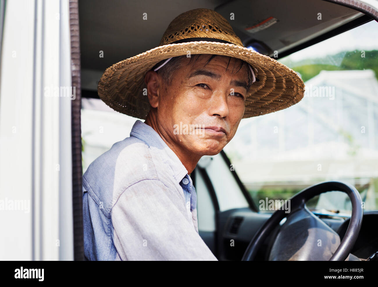 Ein Mann mit Hut sitzt am Steuer eines LKW. Stockfoto