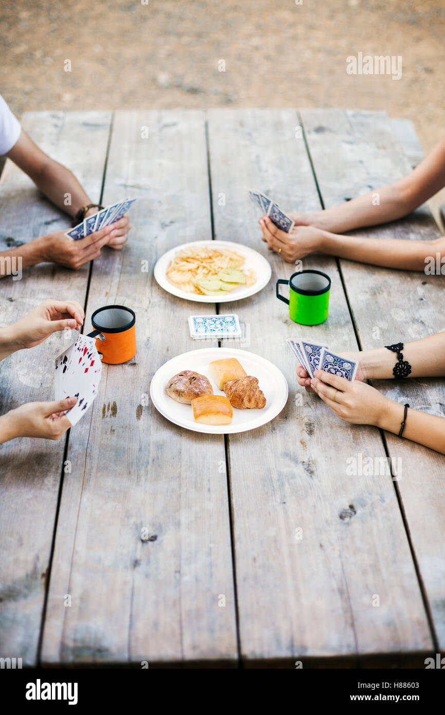 Nahaufnahme von vier Personen sitzen an einem Tisch, Spielkarten. Stockfoto