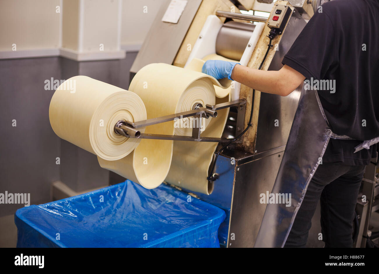 Eine Soba-Nudel-Factory.  Blätter frische Nudel Teig durch eine große Pressmaschine übergeben wird. Stockfoto