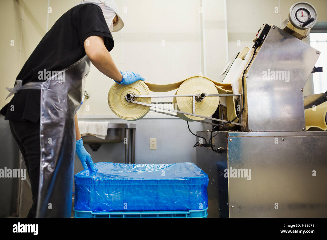 Eine Soba-Nudel-Factory.  Blätter frische Nudel Teig durch eine große Pressmaschine übergeben wird. Stockfoto