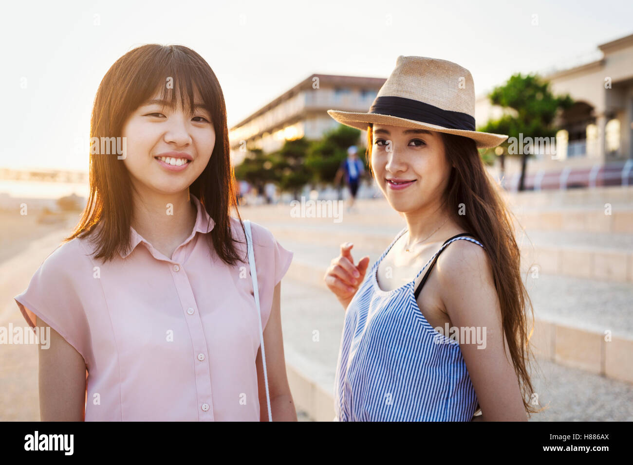 Zwei junge Frauen mit langen braunen Haaren außerhalb eines Einkaufszentrums. Stockfoto