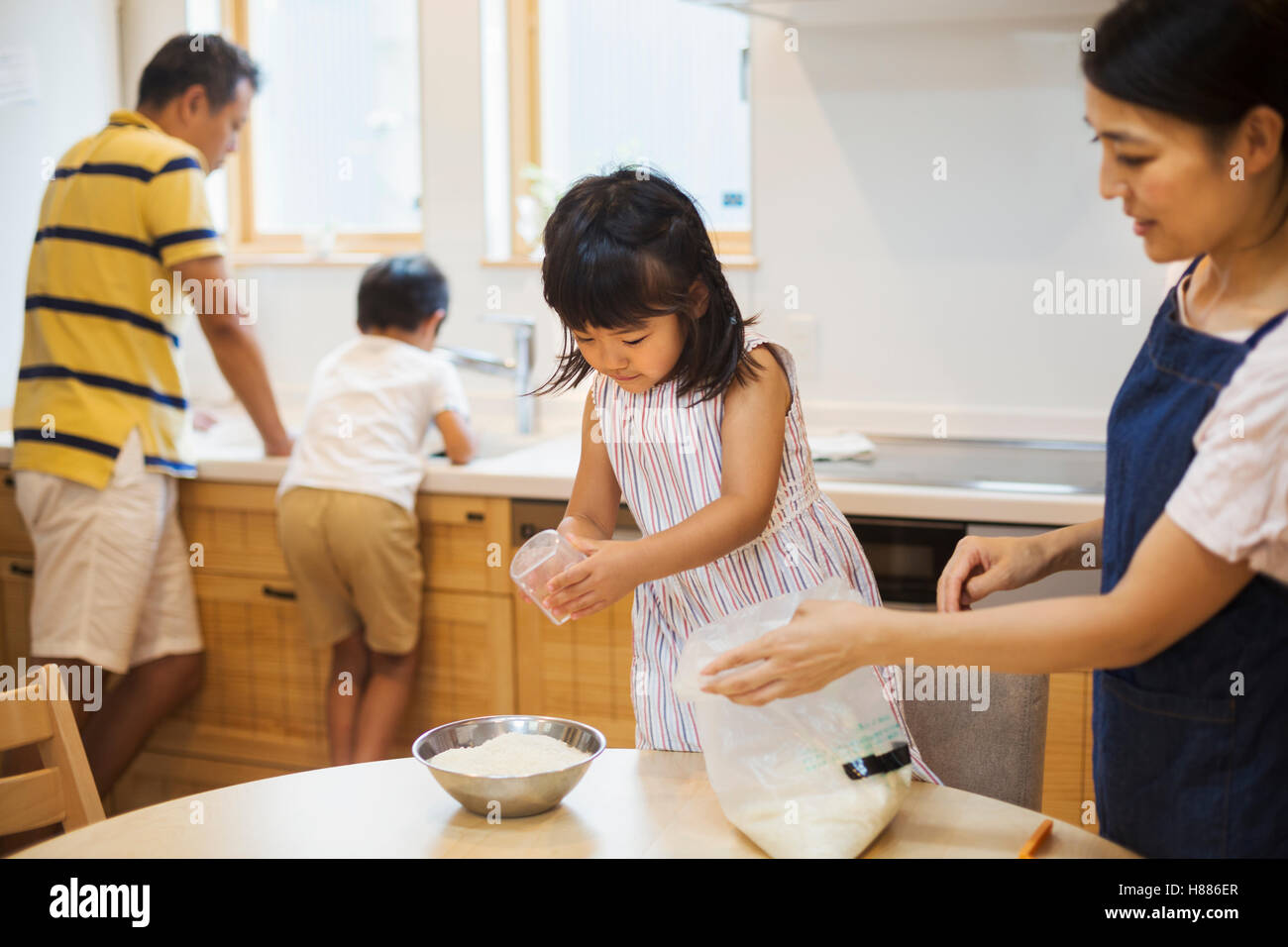 Haus der Familie. Zwei Eltern und zwei Kinder, eine Mahlzeit zuzubereiten. Stockfoto