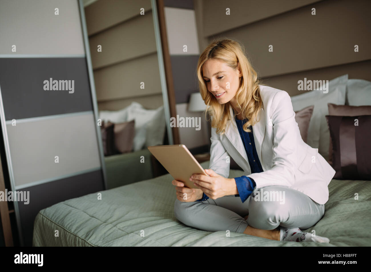 Geschäftsfrau mit Tablet zu Hause im Bett Stockfoto
