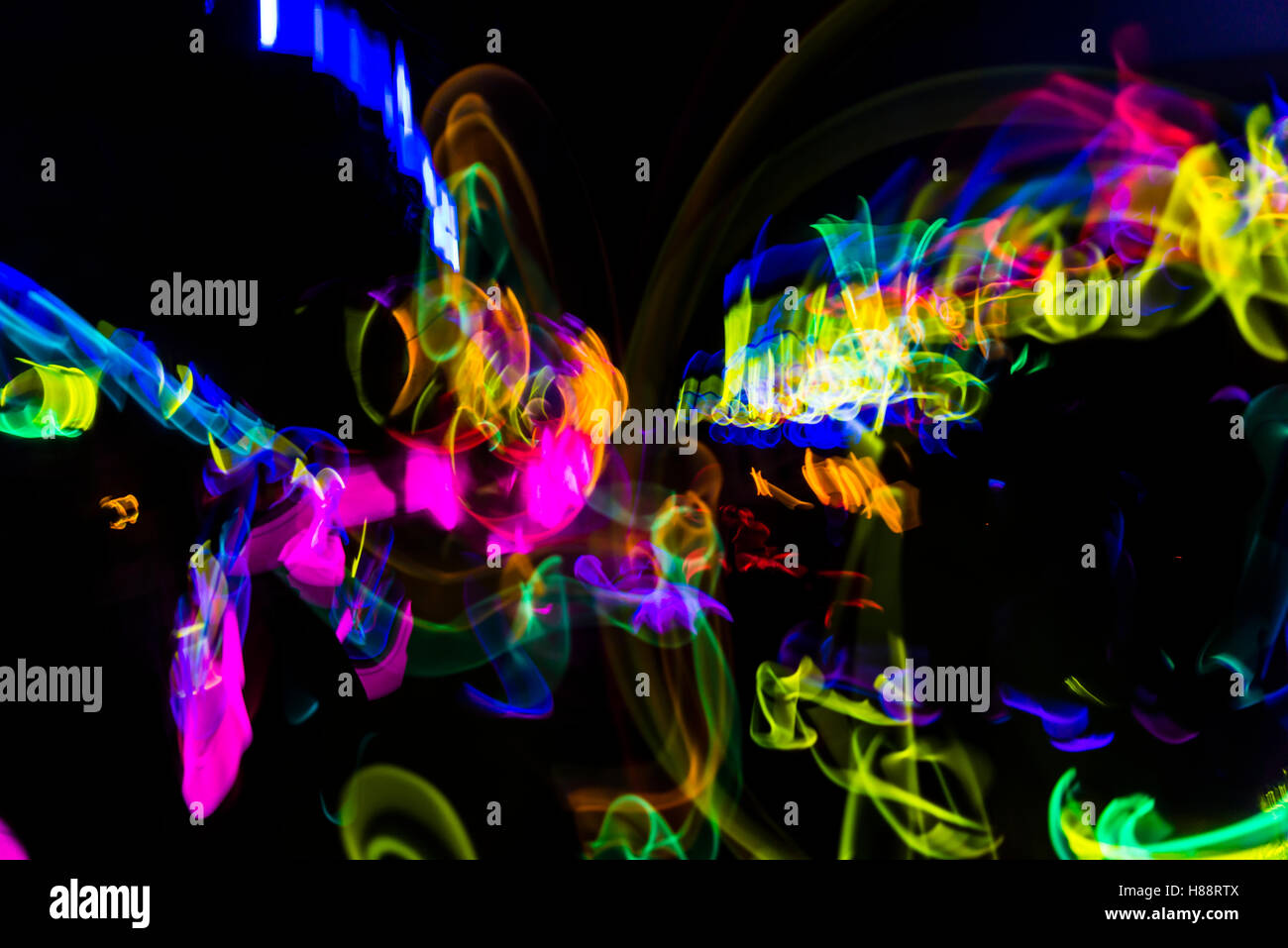 Bunte Leuchten aus Stöcken auf einer dunklen Party mit Langzeitbelichtung Lichteffekt Stockfoto