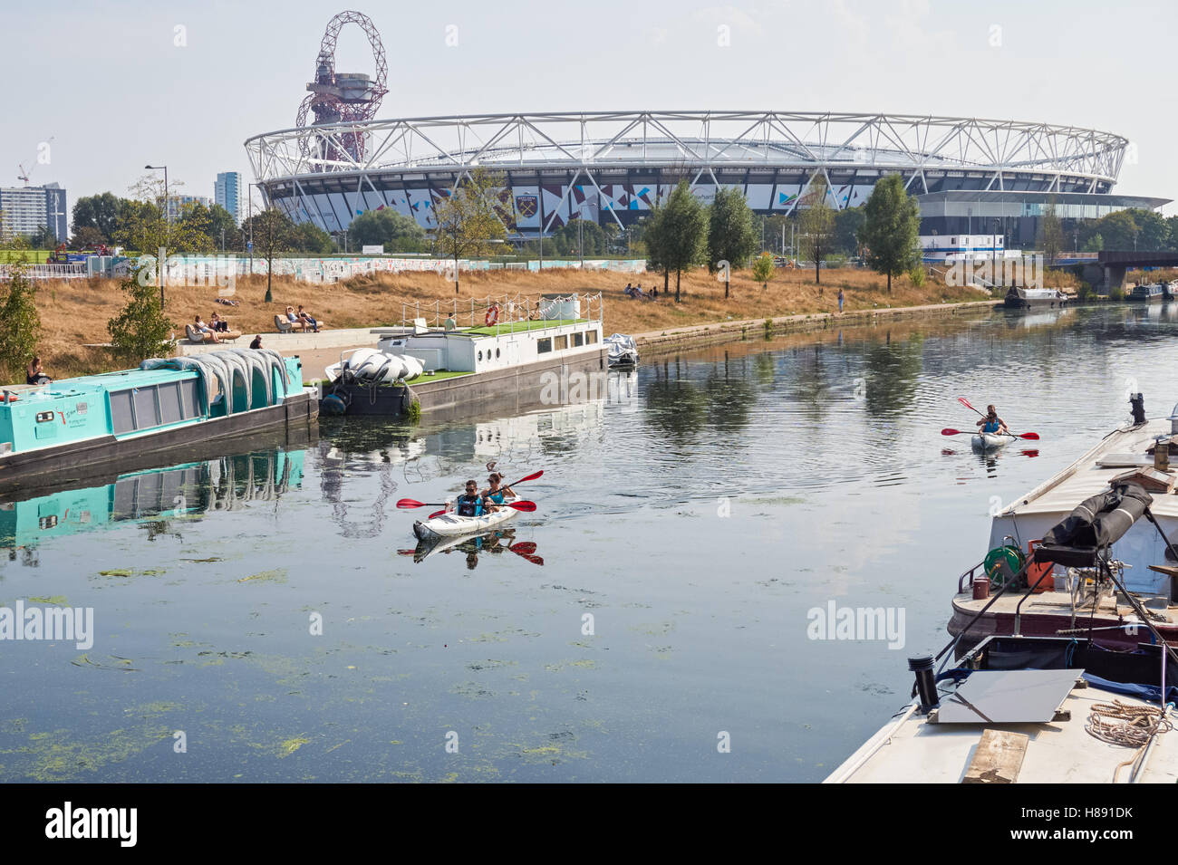 Menschen Kajakfahren auf dem Fluss Lea in Stratford mit London Stadium im Hintergrund, London England Vereinigtes Königreich UK Stockfoto
