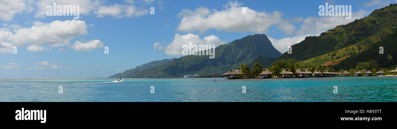 Panoramablick über die grünen Berge mit Resort und türkisblaue Lagune an der zerklüfteten Küste der tropischen Insel Moorea. Stockfoto