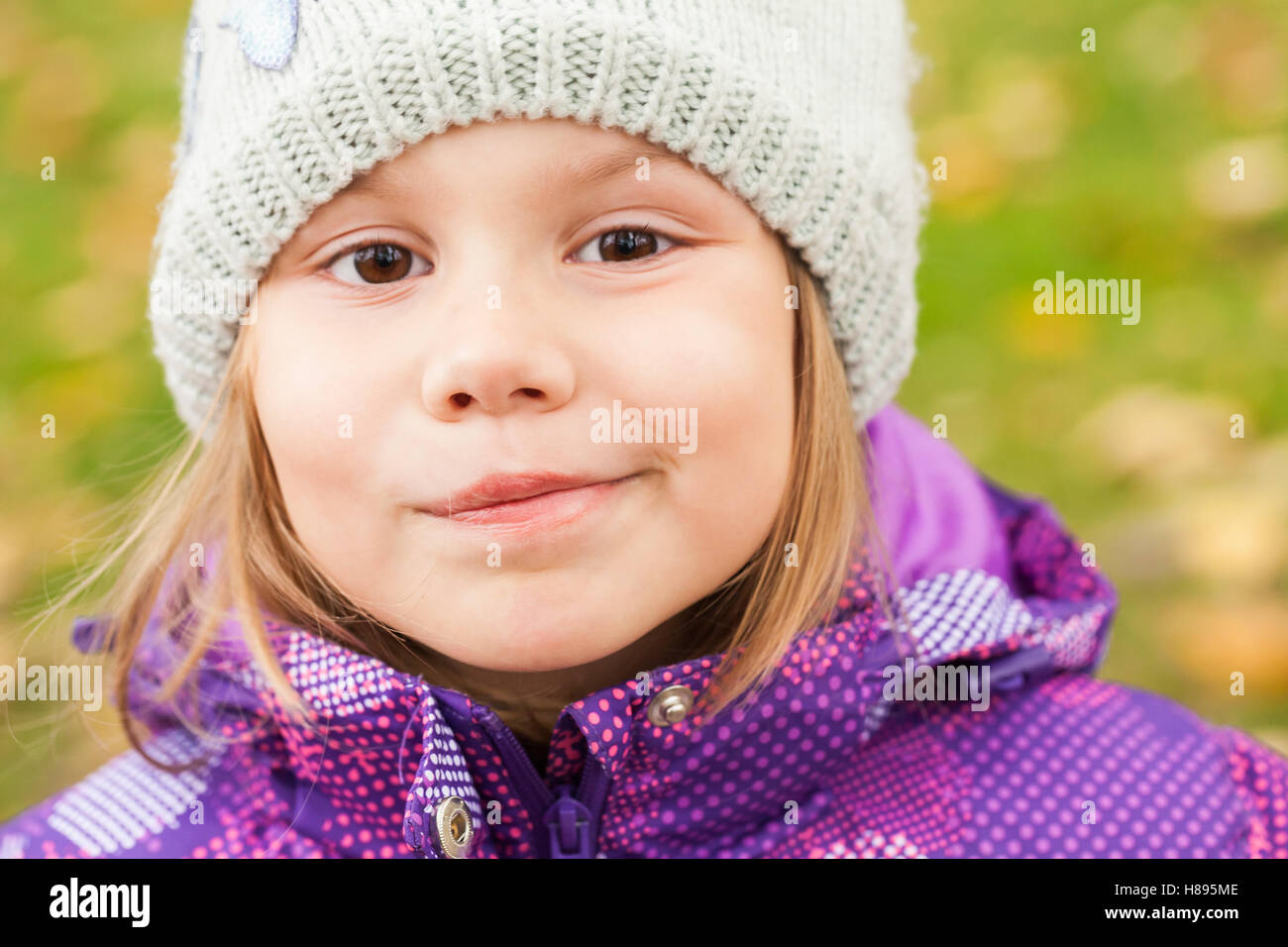 Lustig Lächeln kaukasischen kleines Mädchen, Nahaufnahme outdoor Portrait, Wandern im herbstlichen Park Stockfoto