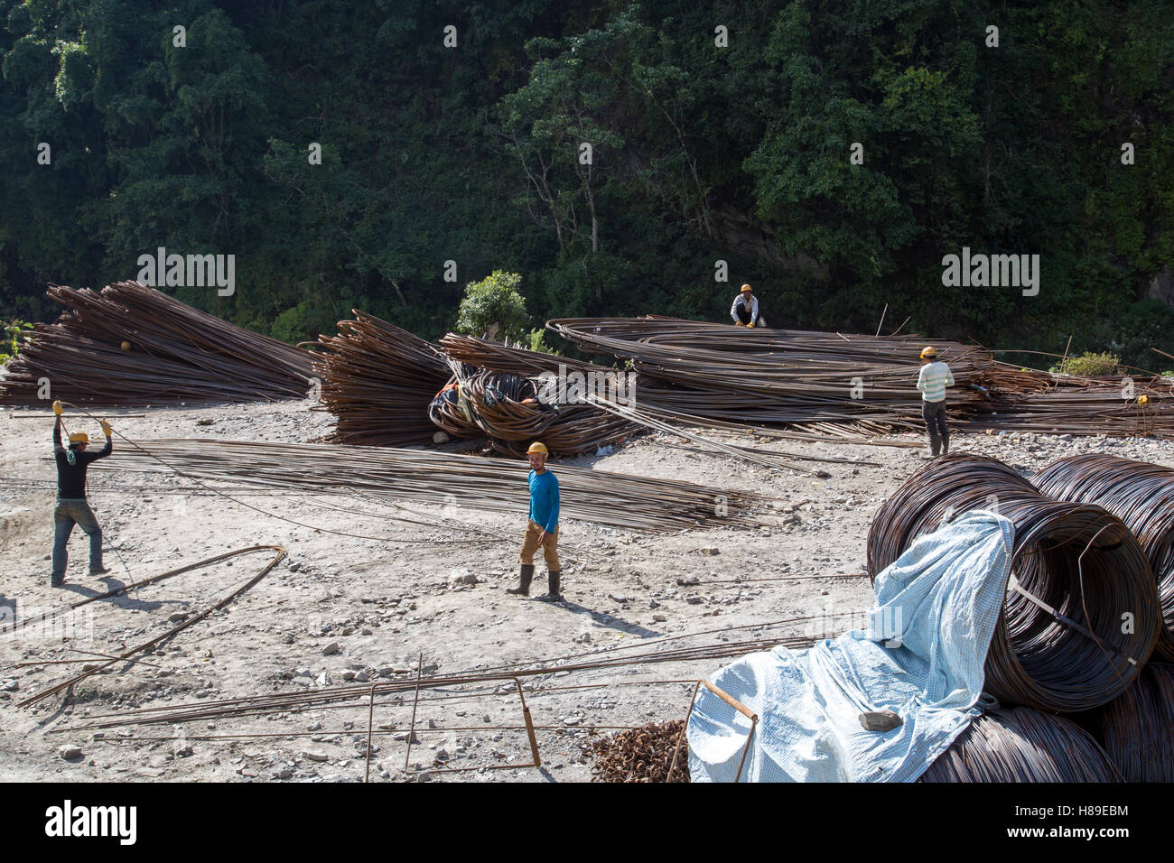 Bhulbhule, Nepal - 23. Oktober 2014: Arbeiter mit Stahlstangen auf der Baustelle des oberen Marsyangdi-Wasserkraft-Projekt Stockfoto
