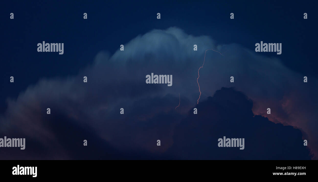 Paar von Blitzeinschlägen, die aus einem wachsenden Gewitter Stockfoto