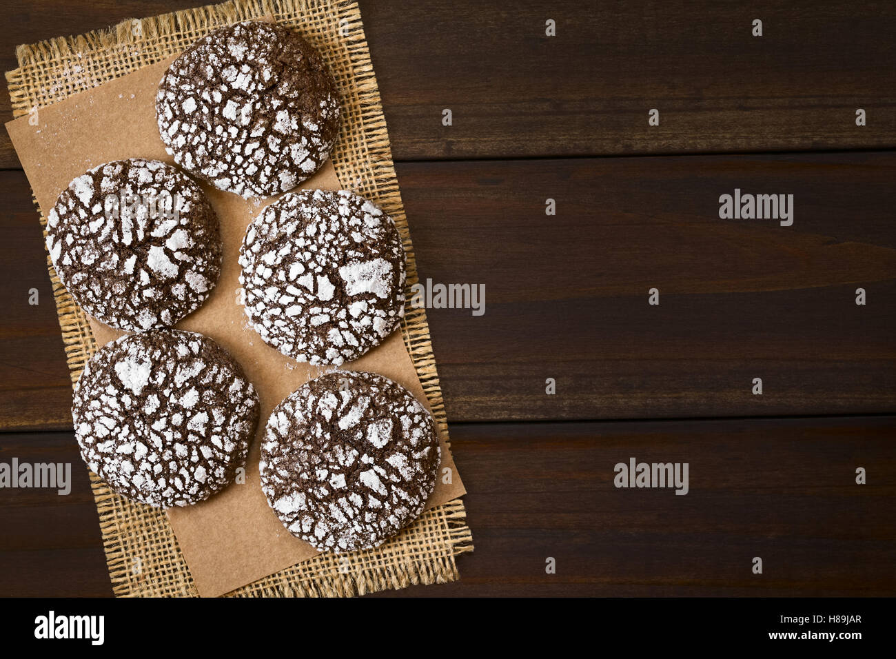 Schokolade Crinkle Cookies, traditionellen American Christmas Cookies, overhead auf dunklem Holz mit Tageslicht fotografiert Stockfoto