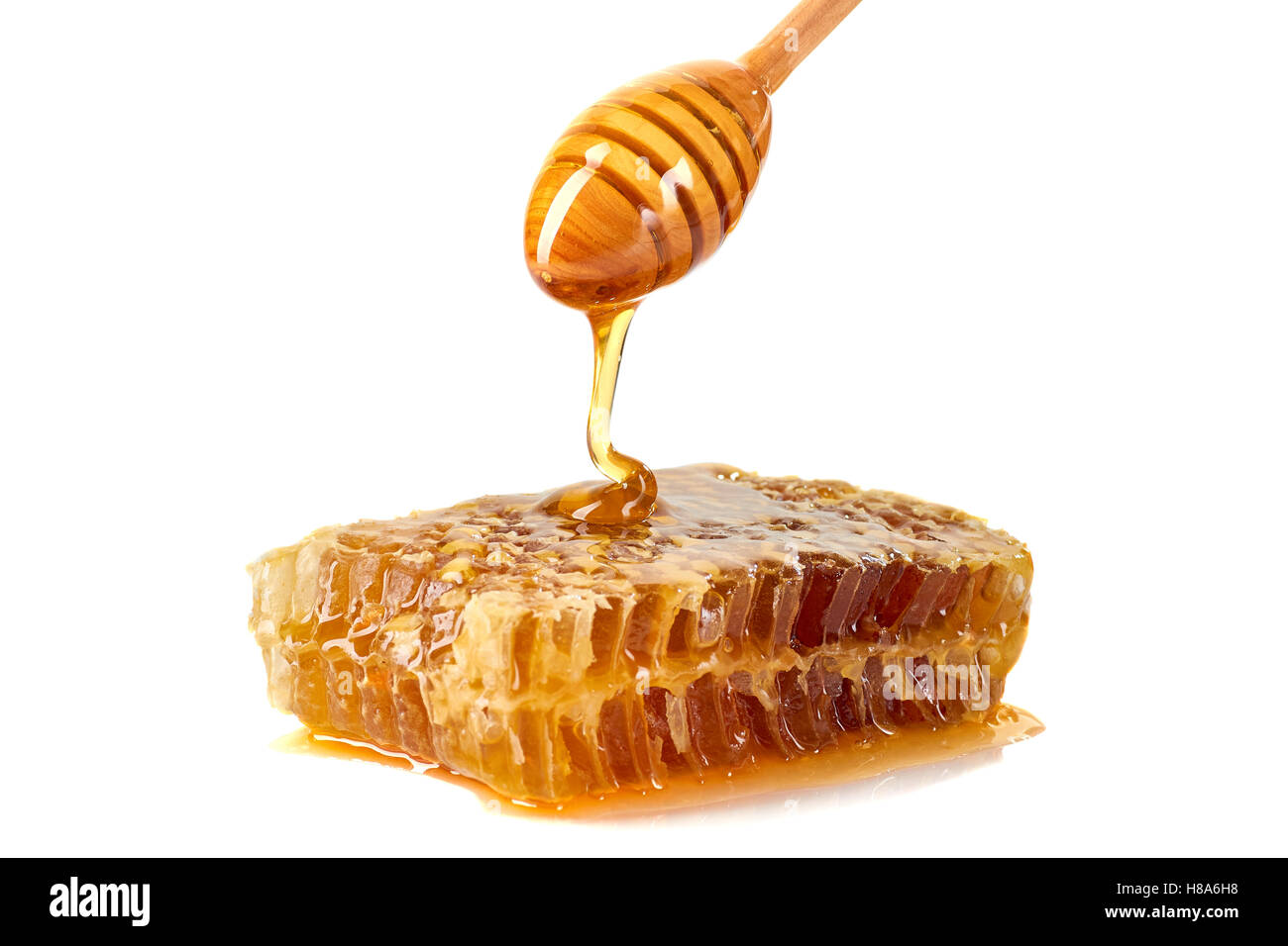 Honig tropft auf Waben auf weißem Hintergrund Stockfoto