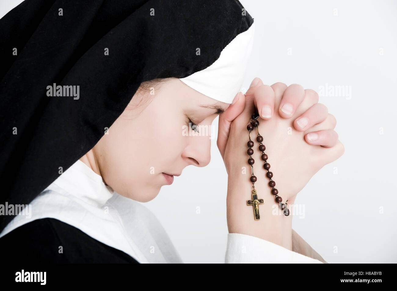 Nonne beten den Rosenkranz Stockfoto