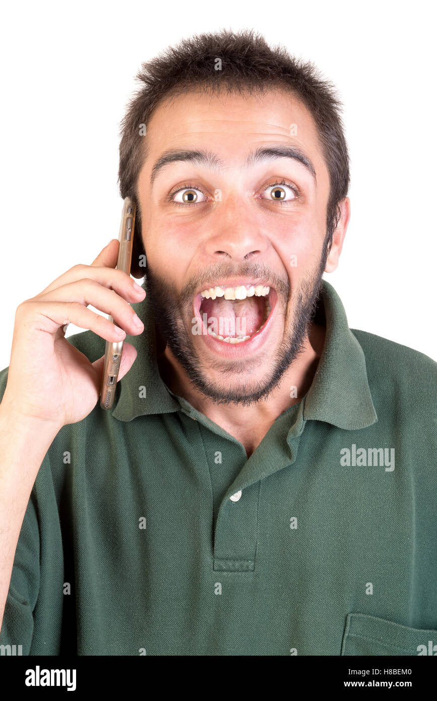 junger Mann mit Handy tun lustige Gesichter isoliert in weiß Stockfoto