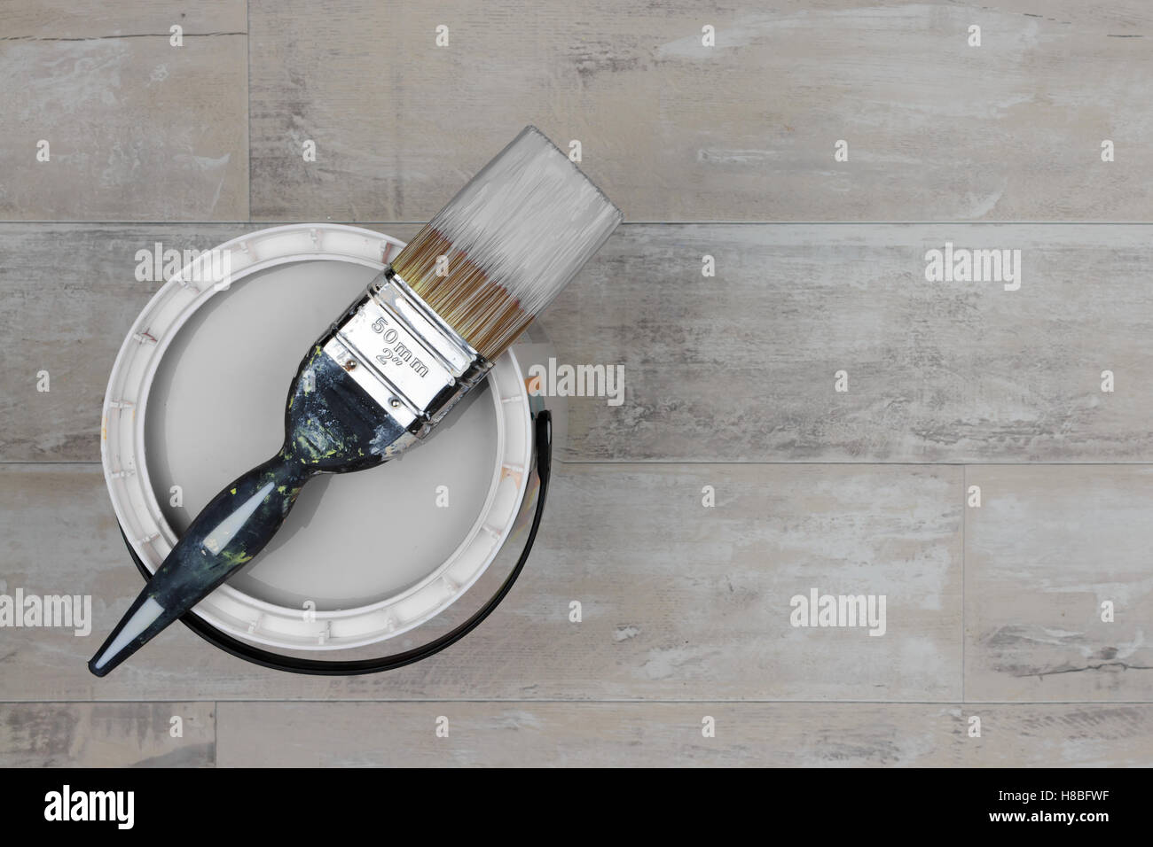 Kann leicht graue Farbe mit einem geladenen Pinsel Stand auf einem Holzboden shabby Stil Stockfoto