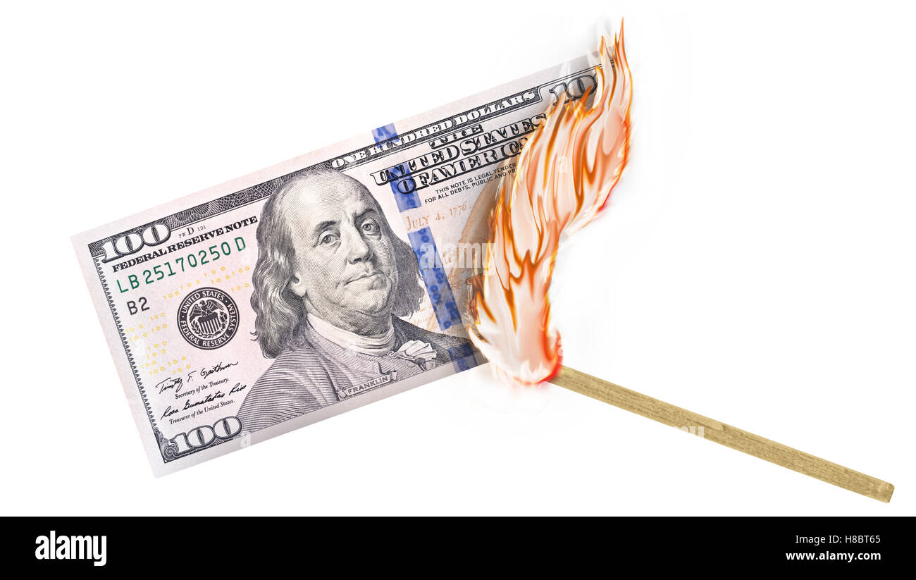 Eine Banknote wird von einer Übereinstimmung mit dem Brennen in einer großen Flamme verbrannte. Stockfoto