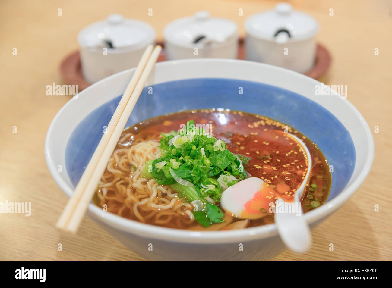 Würzige asiatische Ramen Nudelsuppe in Schüssel geben. Stockfoto