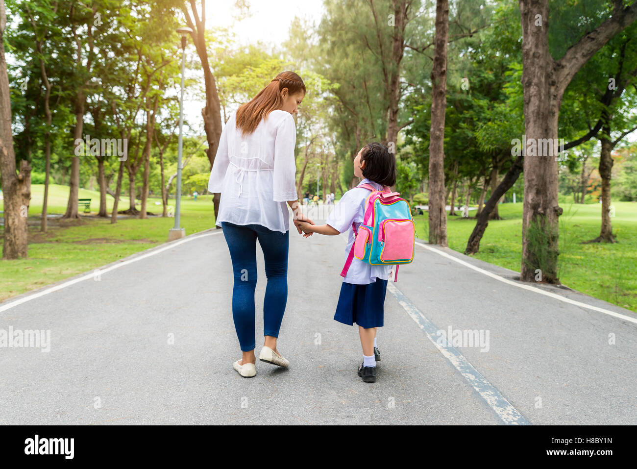 Asiatische Mutter und Tochter Schüler zu Fuß zur Schule. Schülerinnen und Schüler. Stockfoto