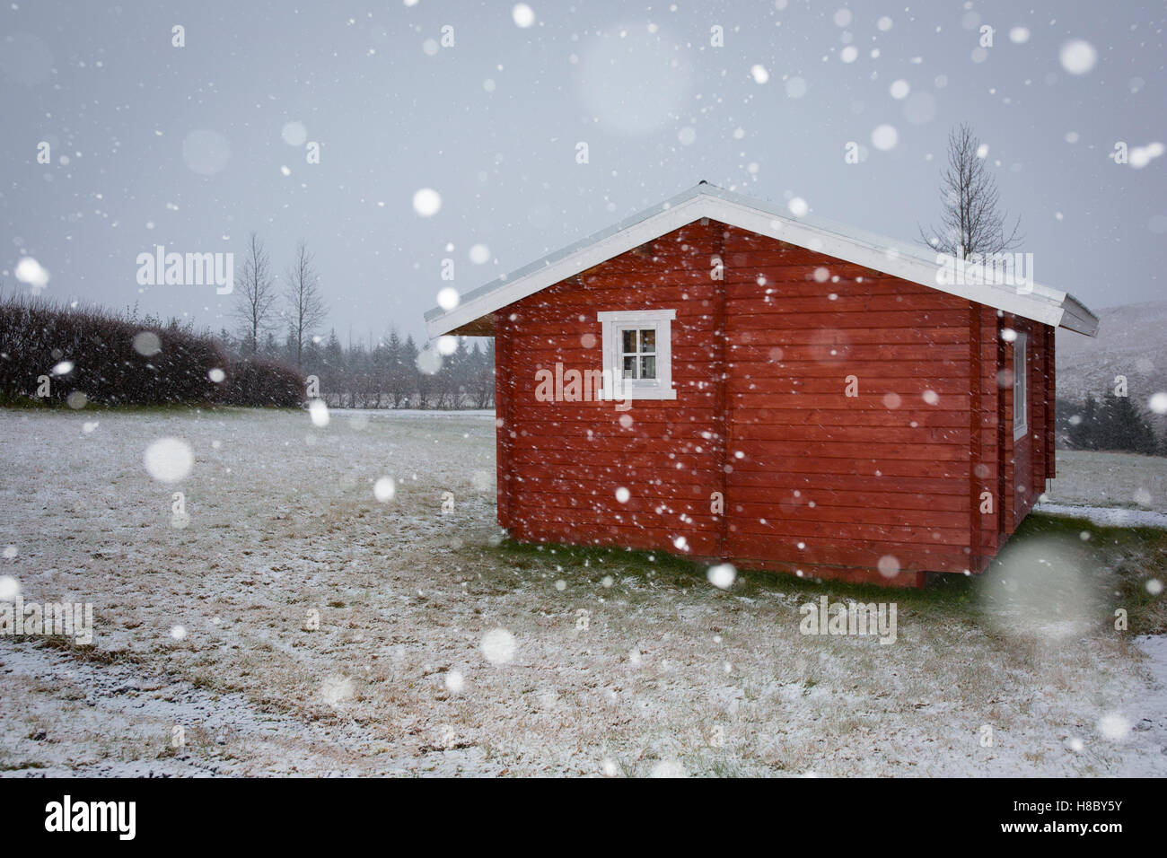 Schnee fällt in der Nähe einer Pension Hütte vor den Toren Kirkjubaejarklaustur im südöstlichen Island Stockfoto