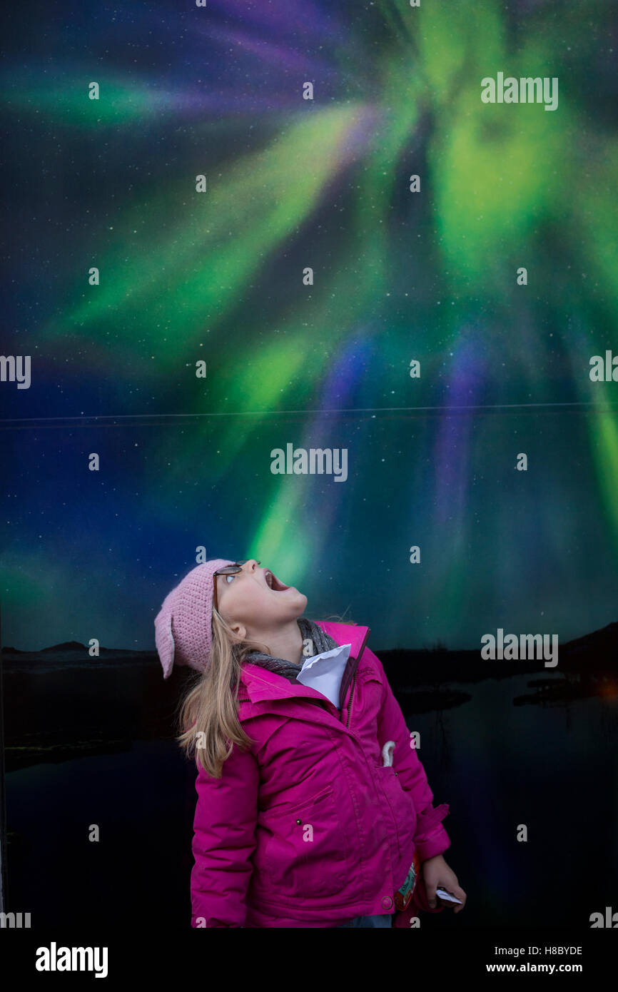 Ein junges Mädchen schaut ein Plakat der Nordlichter in Reykjavik, Island Stockfoto