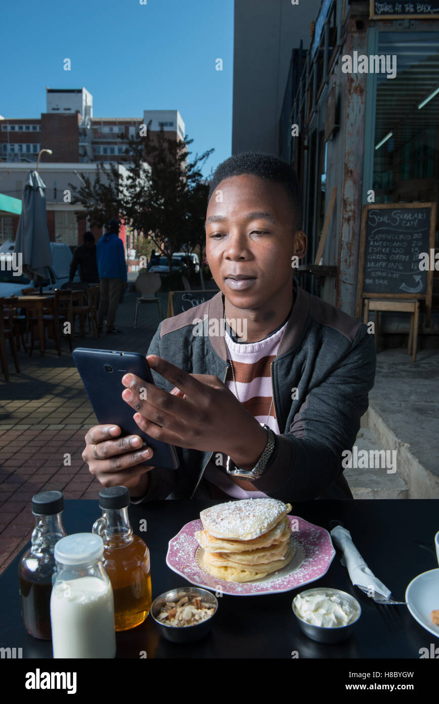 Mann mit einem Tablet in einem Café in Johannesburg Stockfoto