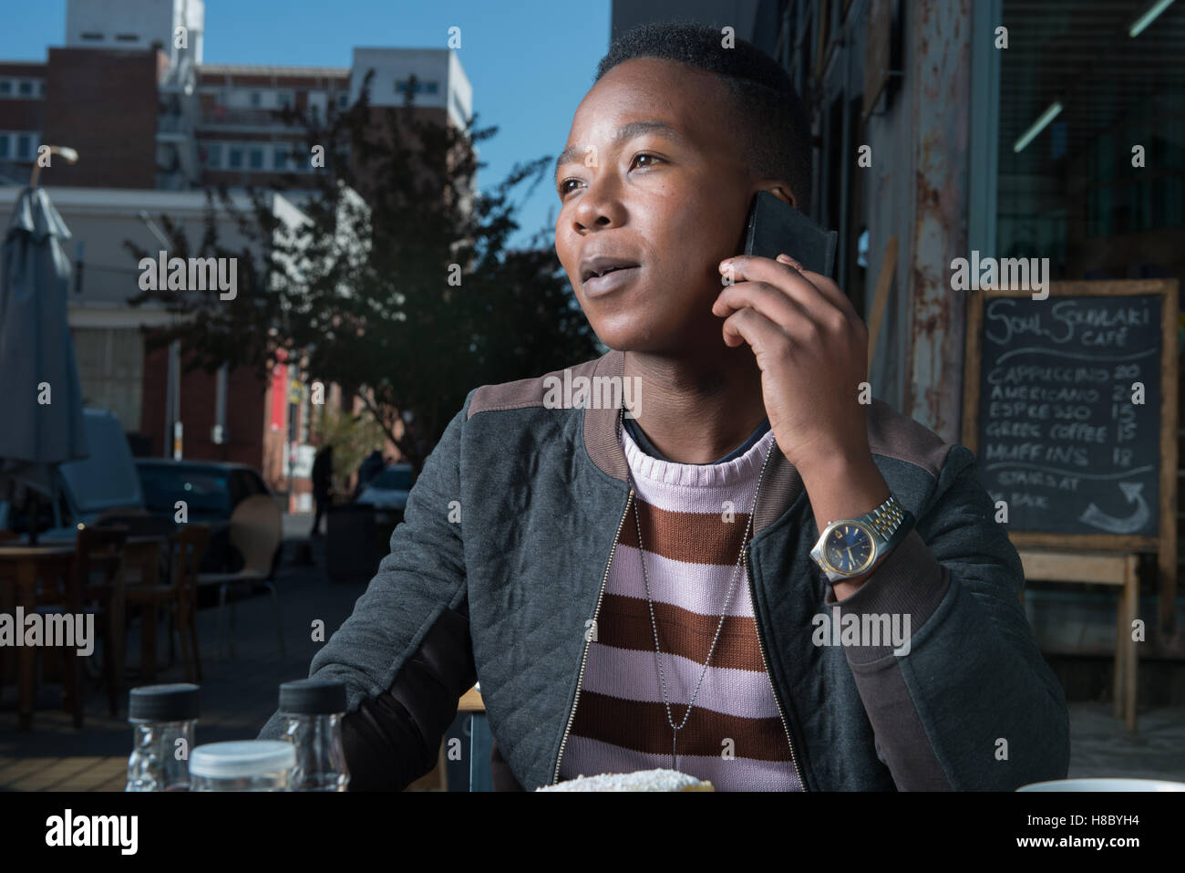Mann sprechen auf einem Handy in einem Café in Johannesburg Stockfoto