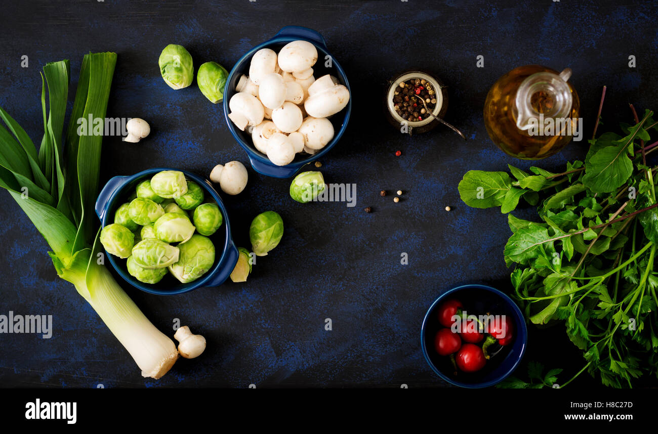 Diät-Menü. Zutaten: Gemüse - Rosenkohl, Champignons, Lauch und Kräutern auf einem dunklen Hintergrund. Ansicht von oben. Gemüse Stockfoto