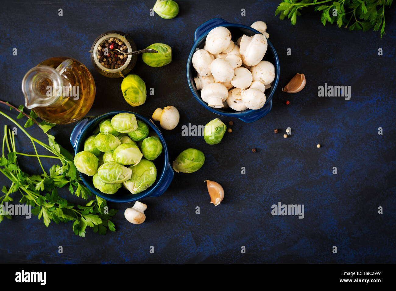Diät-Menü. Zutaten: Gemüse - Rosenkohl, Champignons, Lauch und Kräutern auf einem dunklen Hintergrund. Ansicht von oben. Gemüse Stockfoto