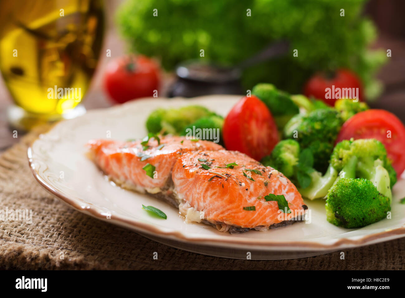 Gebackener Fisch Lachs garniert mit Brokkoli und Tomaten. Diät-Menü. Fisch-Menü. Meeresfrüchte - Lachs. Stockfoto