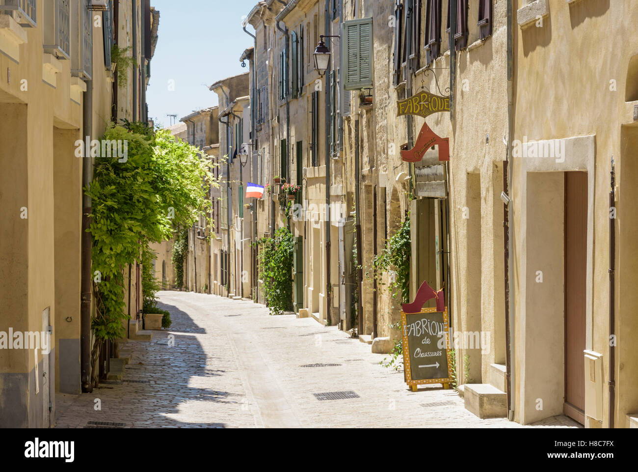Sand farbig Gebäude entlang einer alten Straße innerhalb der mittelalterlichen Stadt Uzès, Gard, Frankreich Stockfoto