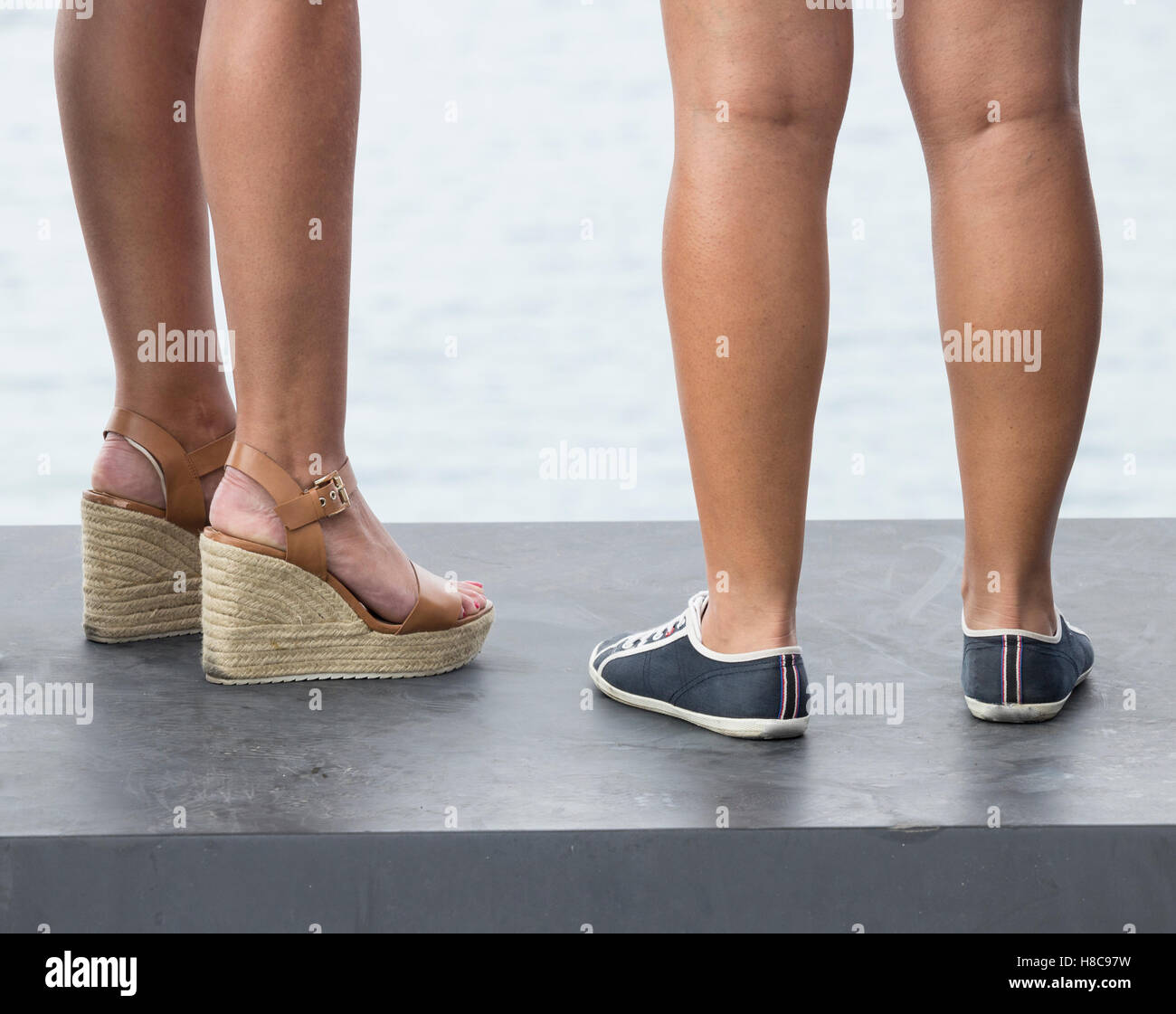 Low Angle View von zwei Frau tragen verschiedene Arten von Schuhen: Fersen und flach. Stockfoto