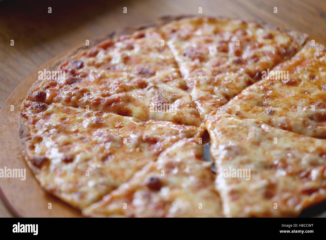 traditionell heißen Käse Pizza auf hölzerne Teller im Restaurant. Stockfoto