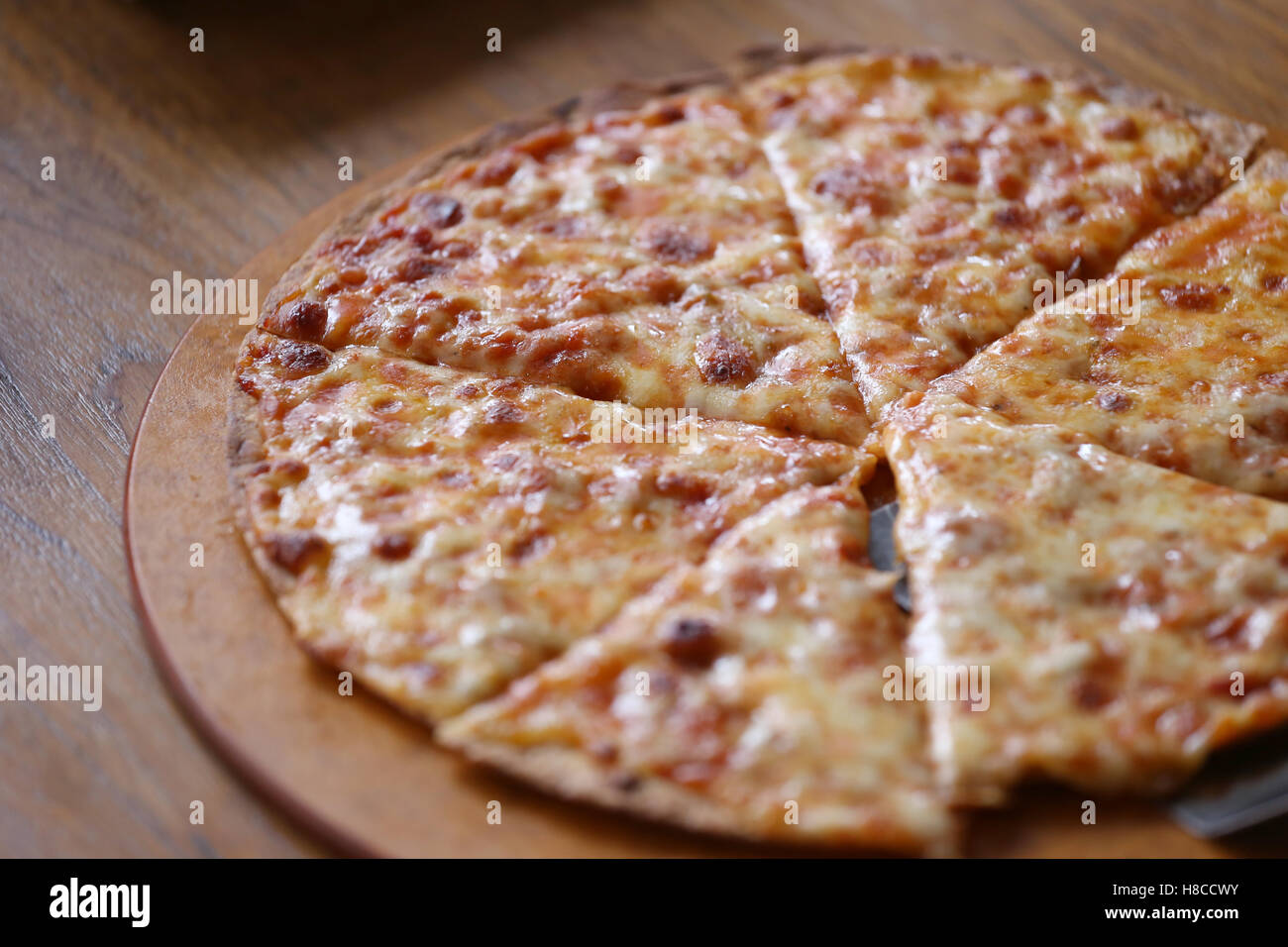 traditionell heißen Käse Pizza auf hölzerne Teller im Restaurant. Stockfoto