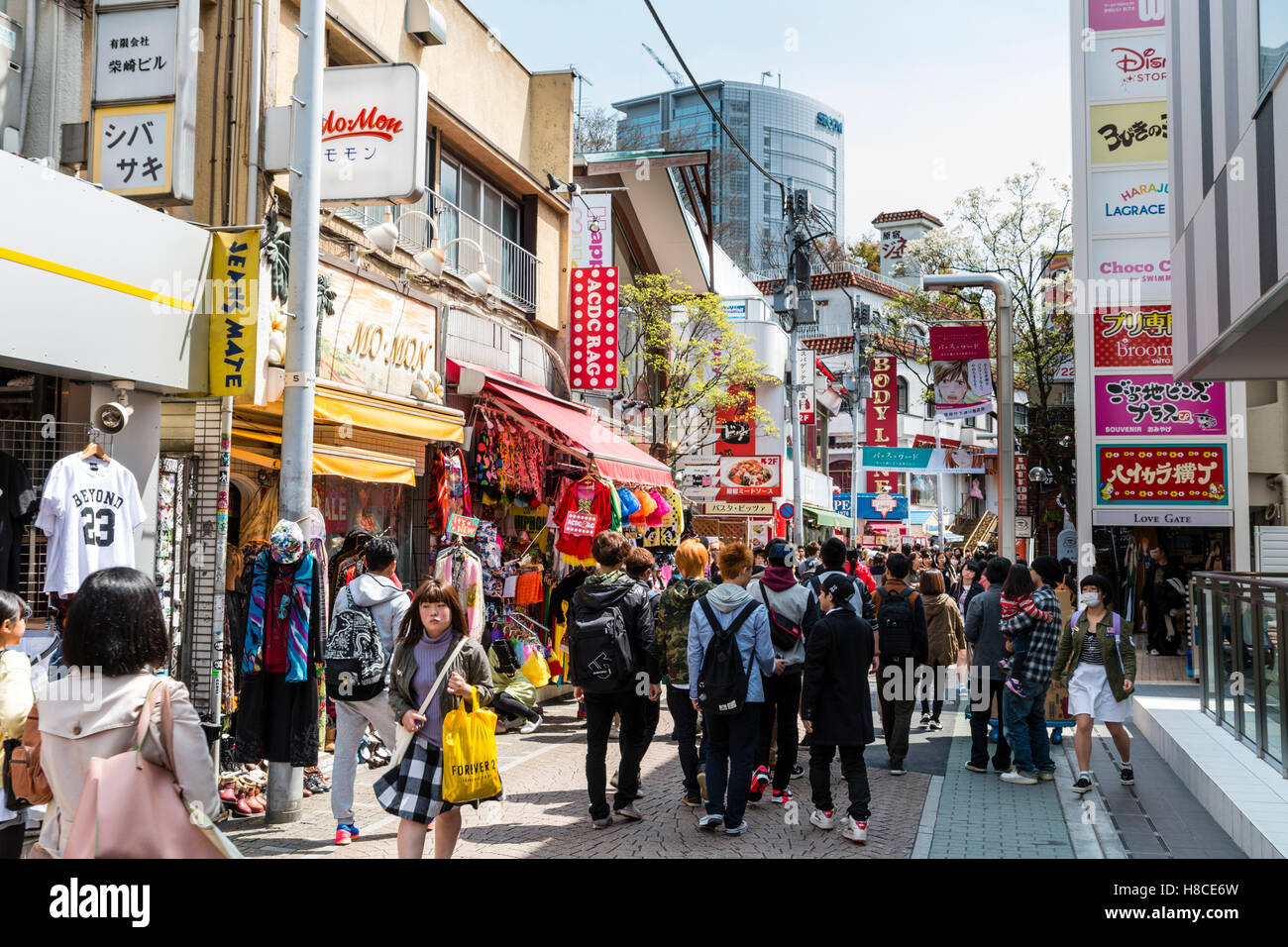 Japan, Tokio, Harajuku, Takeshita-dori. Blick entlang der Straße mit ACDC Rag und anderen Stores, besetzt mit Leuten, Touristen und Käufer. Tagsüber. Stockfoto