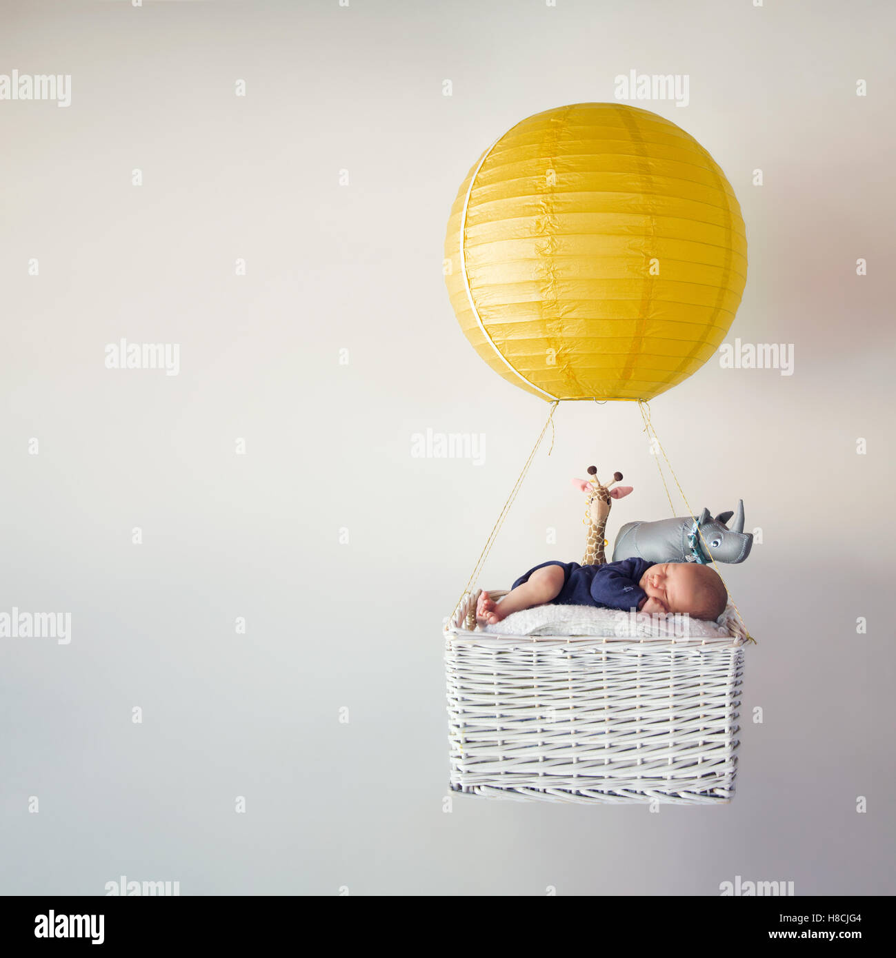 Ein neugeborenes Baby in einer kleinen Luftballon mit seinen Stofftieren Stockfoto
