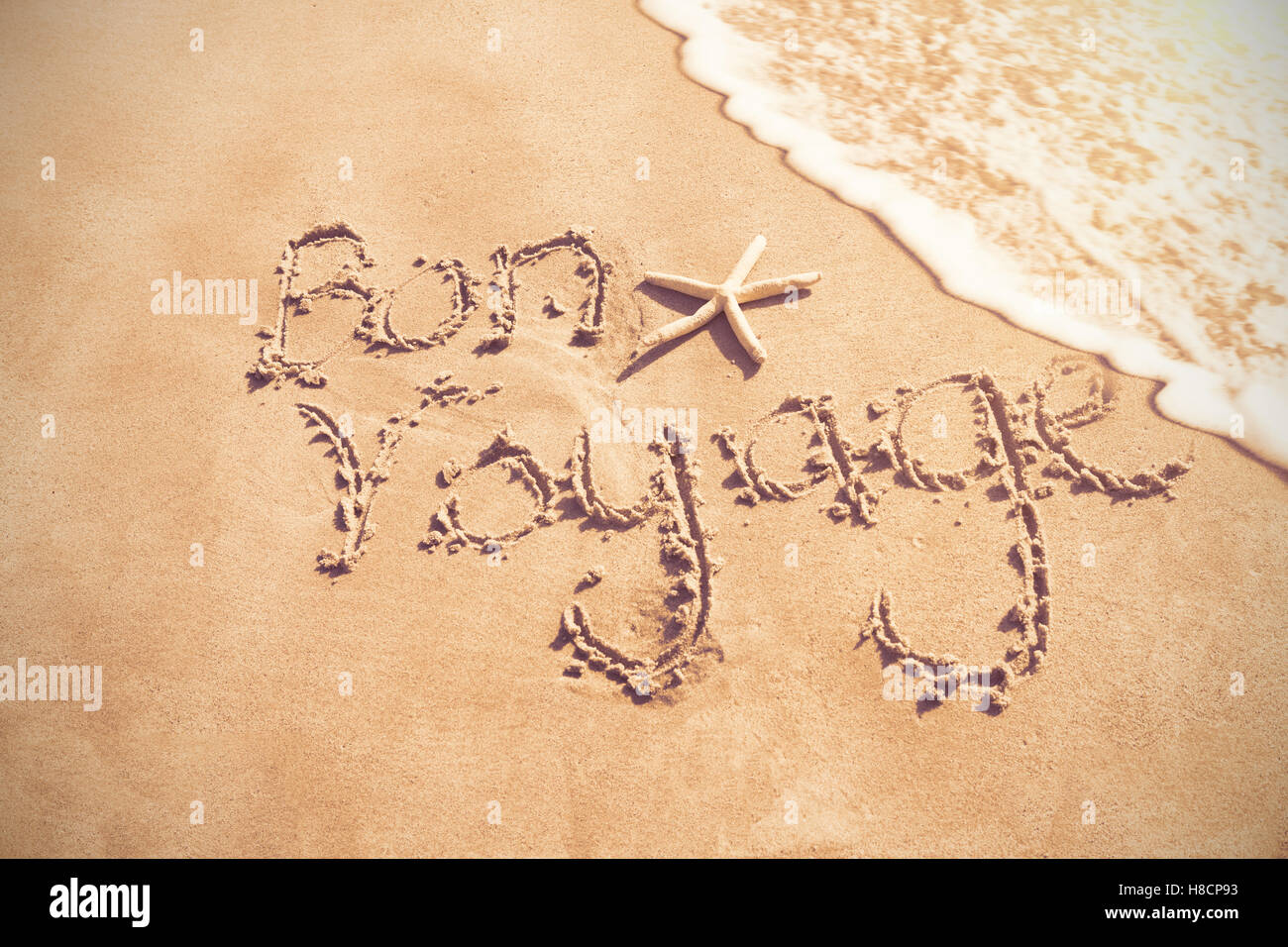 Bon voyage geschrieben am sand Stockfoto