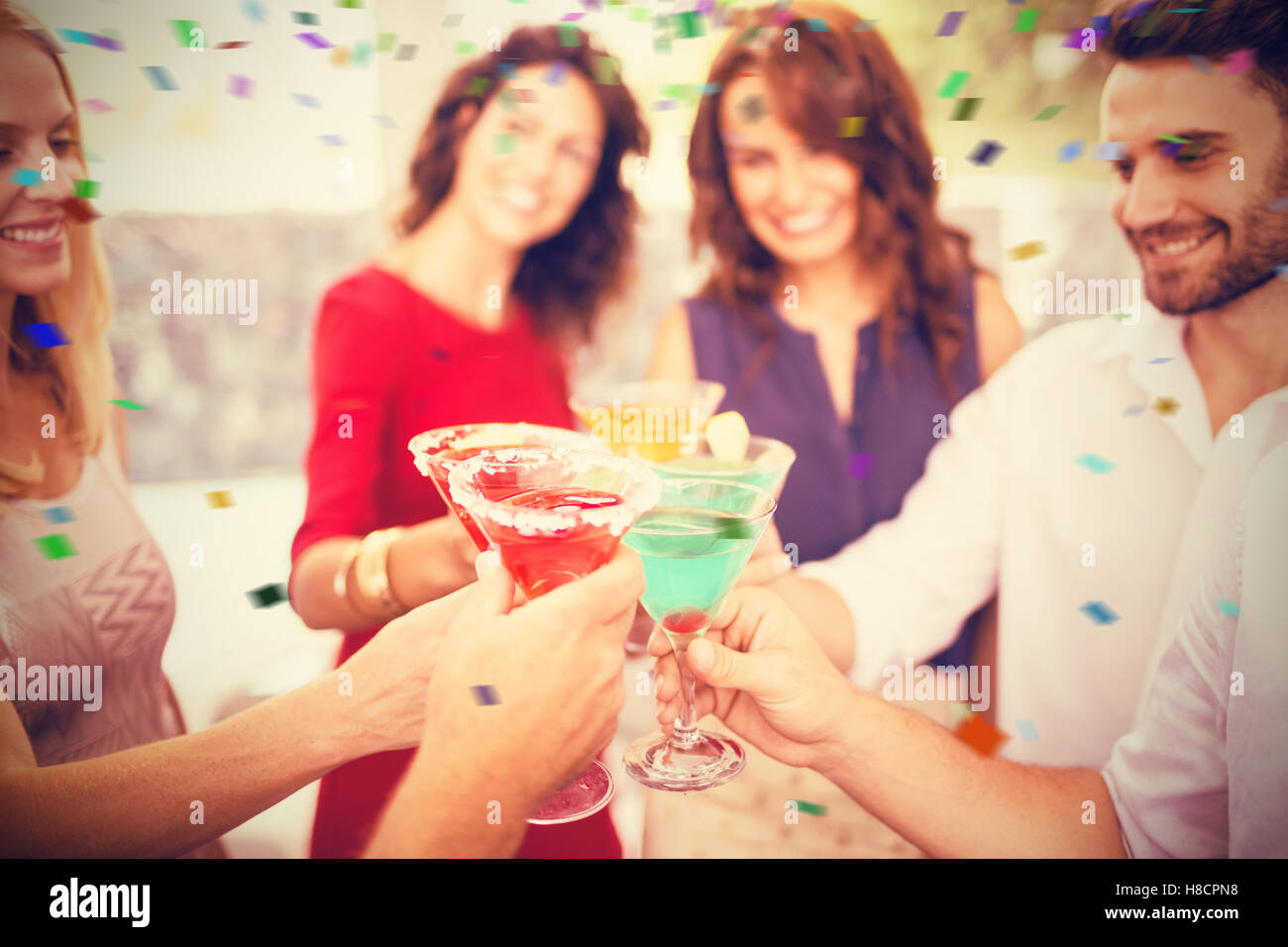 Zusammengesetztes Bild des zugeschnittenen Bildes von Hand Toasten cocktail Stockfoto