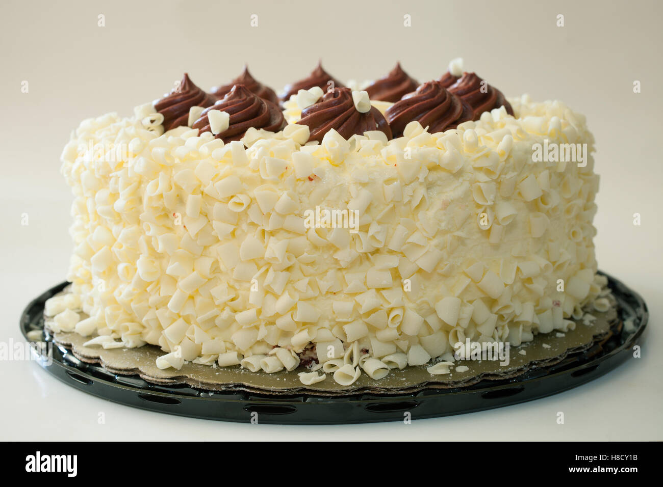 Roter Samt-Kuchen mit Vanille Zuckerguss und Schokolade obendrauf Stockfoto