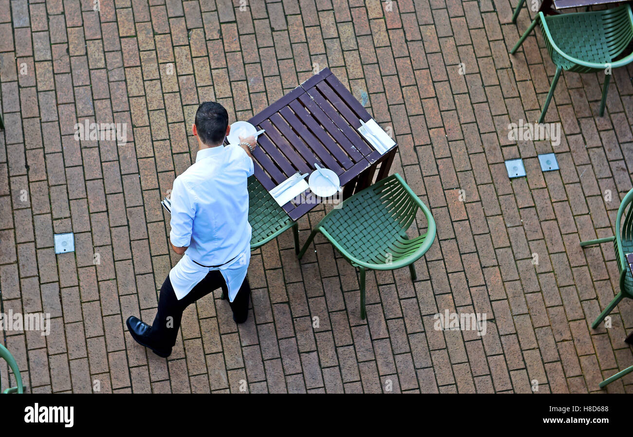 Kellner bereitet Tabellen Service außerhalb der Rätsel & Finnen Meeresfrüchte Restaurant Brighton Seafront UK Stockfoto