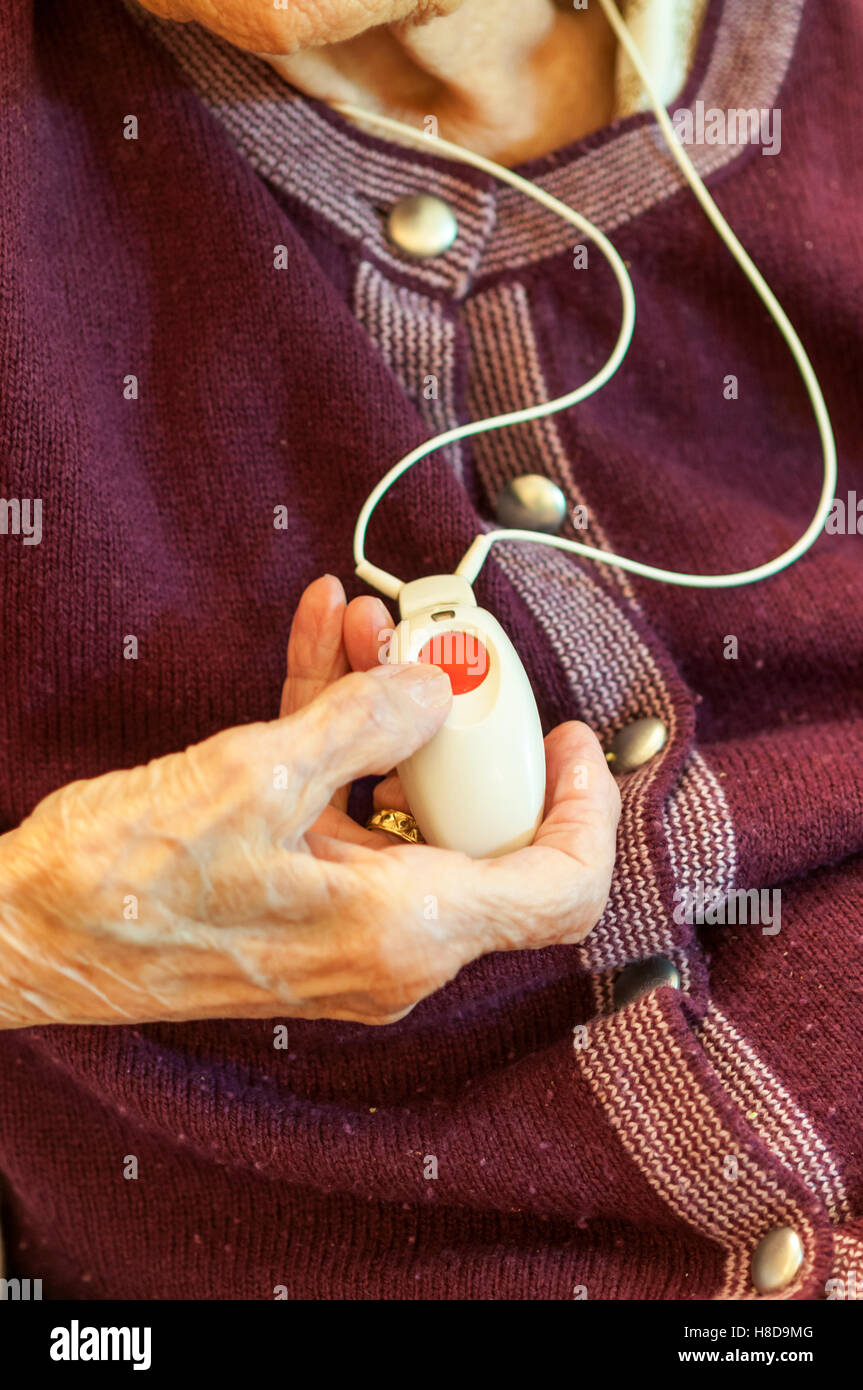 Ein 96 Jahre alte Dame mit ihrem Anruf oder Panik-Knopf als Anhänger, dass sie, um Hilfe in einem Notfall anrufen oder wenn sie umfällt Stockfoto