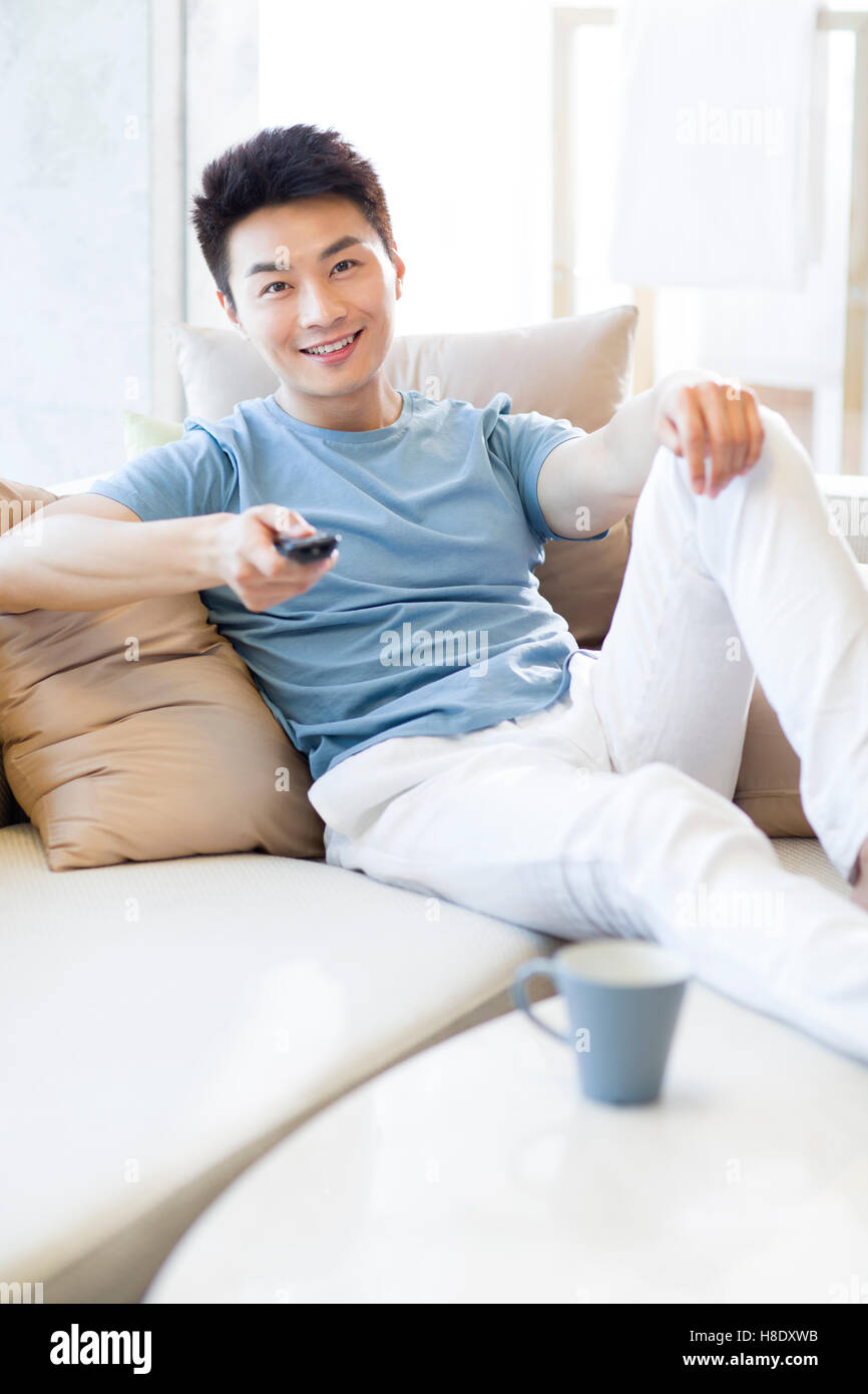 Junge Chinesen Mann vor dem Fernseher zu Hause Stockfoto
