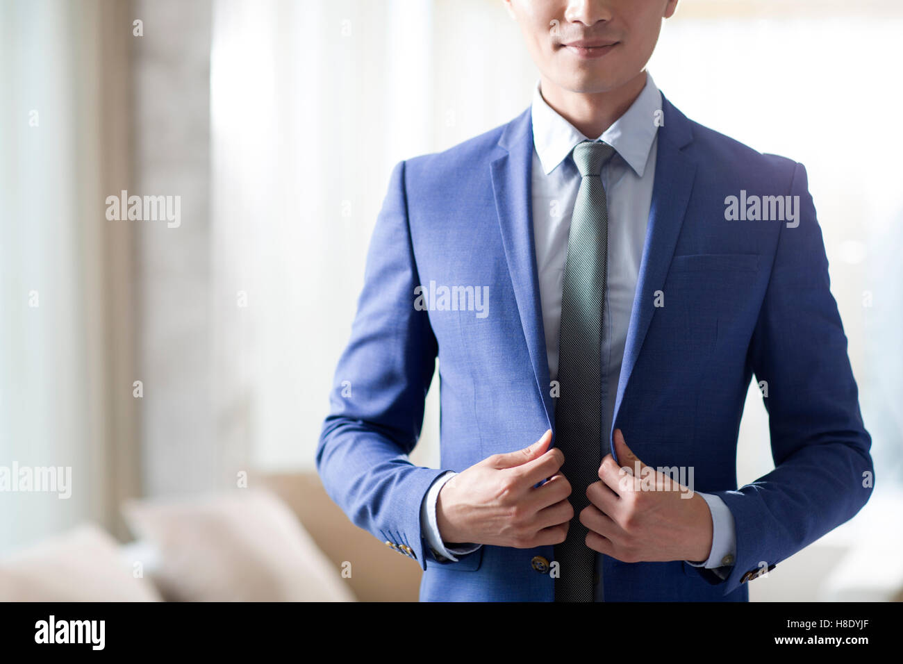 Junge chinesische Geschäftsmann Ankleiden am Morgen Stockfoto