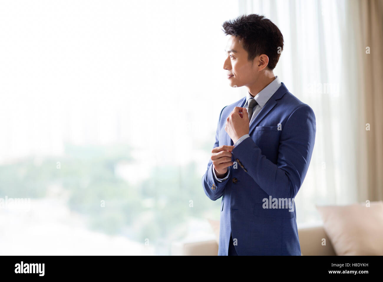 Junge chinesische Geschäftsmann Ankleiden am Morgen Stockfoto