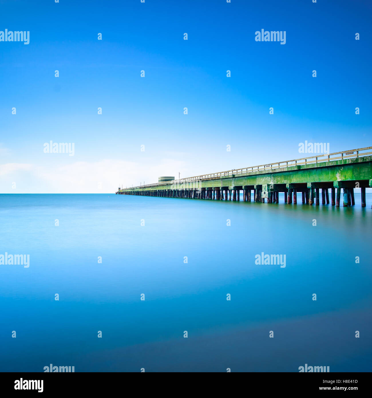 Industrielle Pier auf den Meereshorizont. Seitenansicht. Langzeitbelichtung Fotografie in einem klaren Tag. Stockfoto