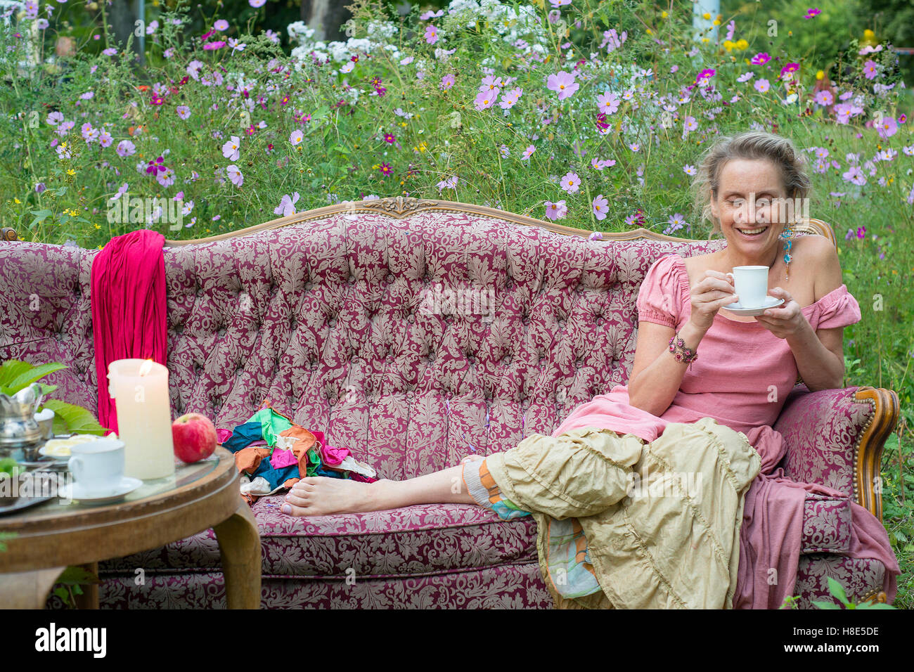 Frau sitzt auf der Couch in den Garten und Tee trinken Stockfoto