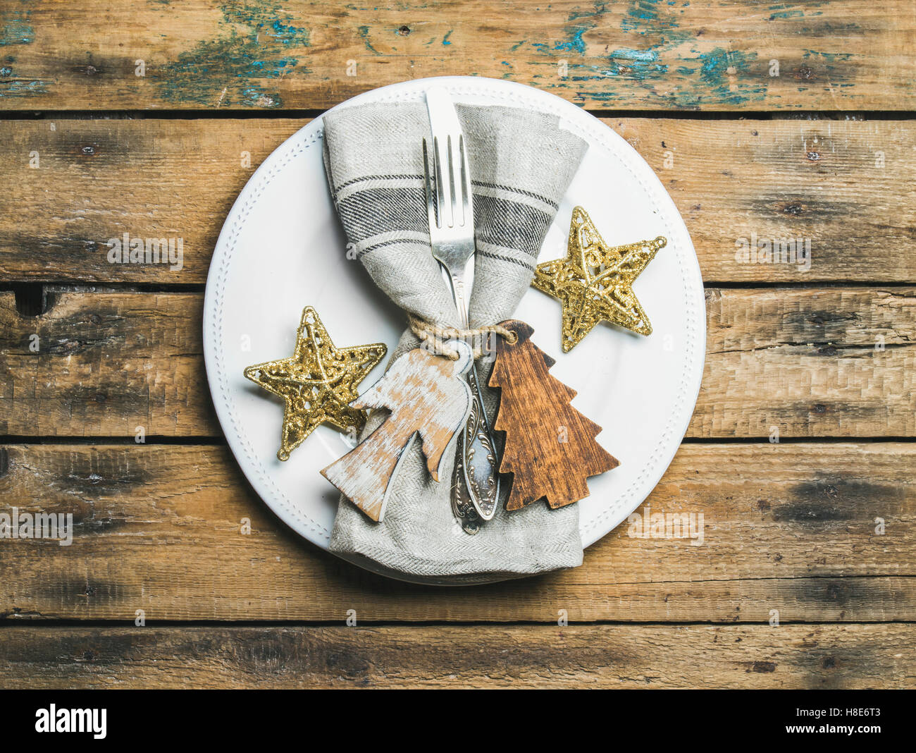 Weihnachten oder Silvester Urlaub rustikale Tischdekoration. Weißen Teller  mit Leinen Servietten, Serviettenringe, Tafelsilber und "goldene Sterne" o  Stockfotografie - Alamy