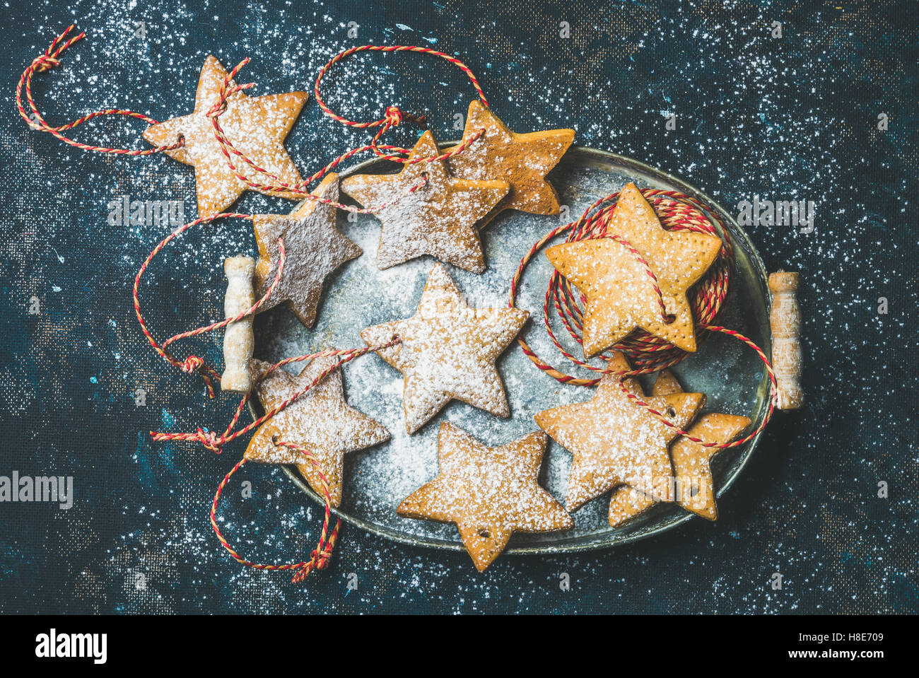 Weihnachten Urlaub sternförmige Lebkuchen für Weihnachtsbaum Dekoration mit Puderzucker und rote Seile in Vintage Metall Stockfoto