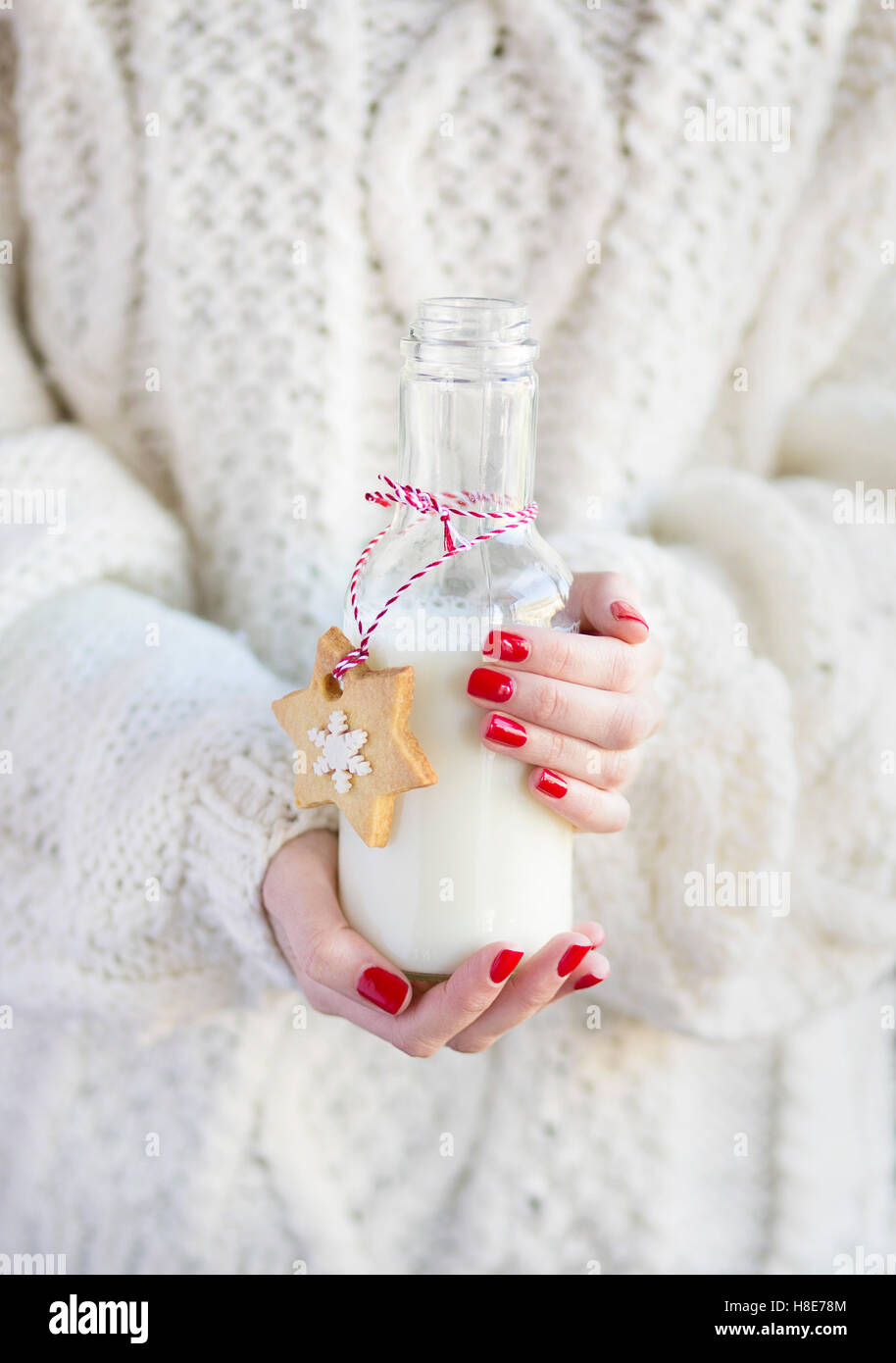 Frau hält eine Flasche Milch mit ein Weihnachtsplätzchen Stockfoto